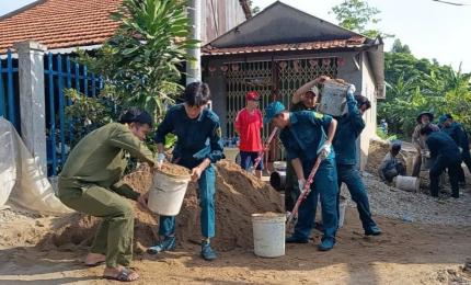 Giữa những ngày giữa tháng Bảy nắng rát, bên dòng kênh nhỏ ngăn cách hai ấp Nhơn Lợi và Nhơn Lộc đã vang lên tiếng máy trộn bê tông hòa cùng tiếng gọi nhau í ới, tiếng cười nói rộn ràng của những người đang cùng chung tay xây dựng cầu Hương Quản. Không giống những công trình xây dựng lớn với máy móc hiện đại, đội ngũ công nhân chuyên nghiệp và những thiết bị thi công quy mô, công trình cầu Hương Quản được dựng xây bằng chính những đôi tay chân chất của người dân quê, bằng sức trẻ và tinh thần xung kích của 
